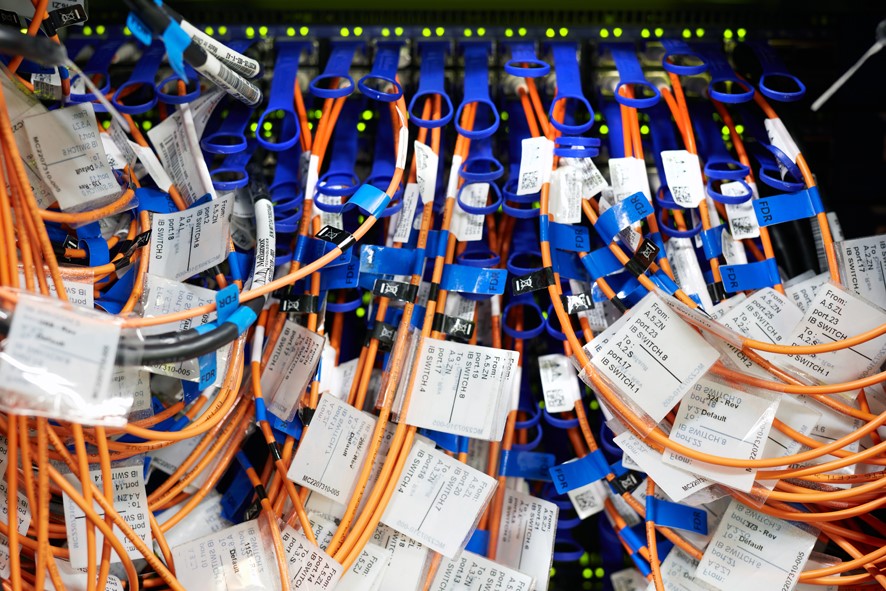 Switch mit Netzwerkkabeln Foto zeigt einen Netzwerk-Switch mit sehr vielen angesteckten Netzwerkkabeln